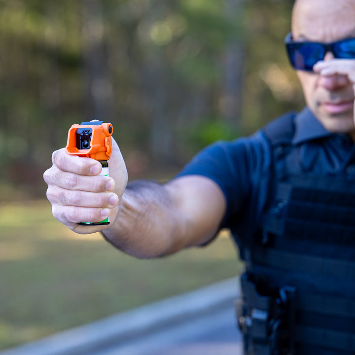 Officer demonstrating controlled OC spray deployment with OC Kit-A
